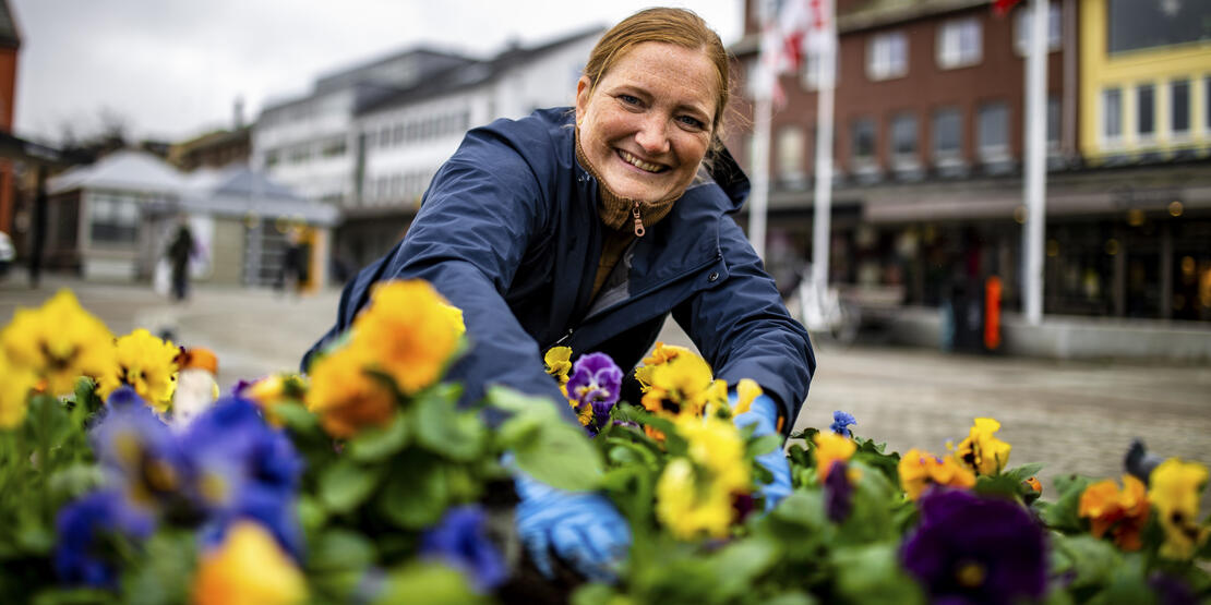 Bildet viser ordfører Ida Pinnerød foran et blomsterbed i Bodø sentrum. 