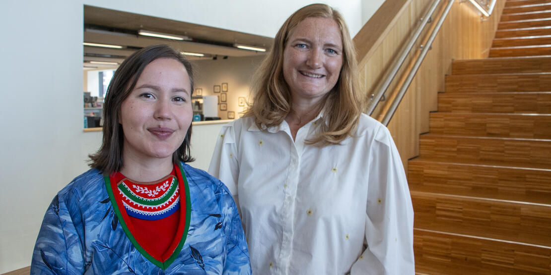 Bildet viser Sametingsråd Maja Kristine Jåma og ordfører Ida Pinnerød i trappen i Stormen bibliotek. 