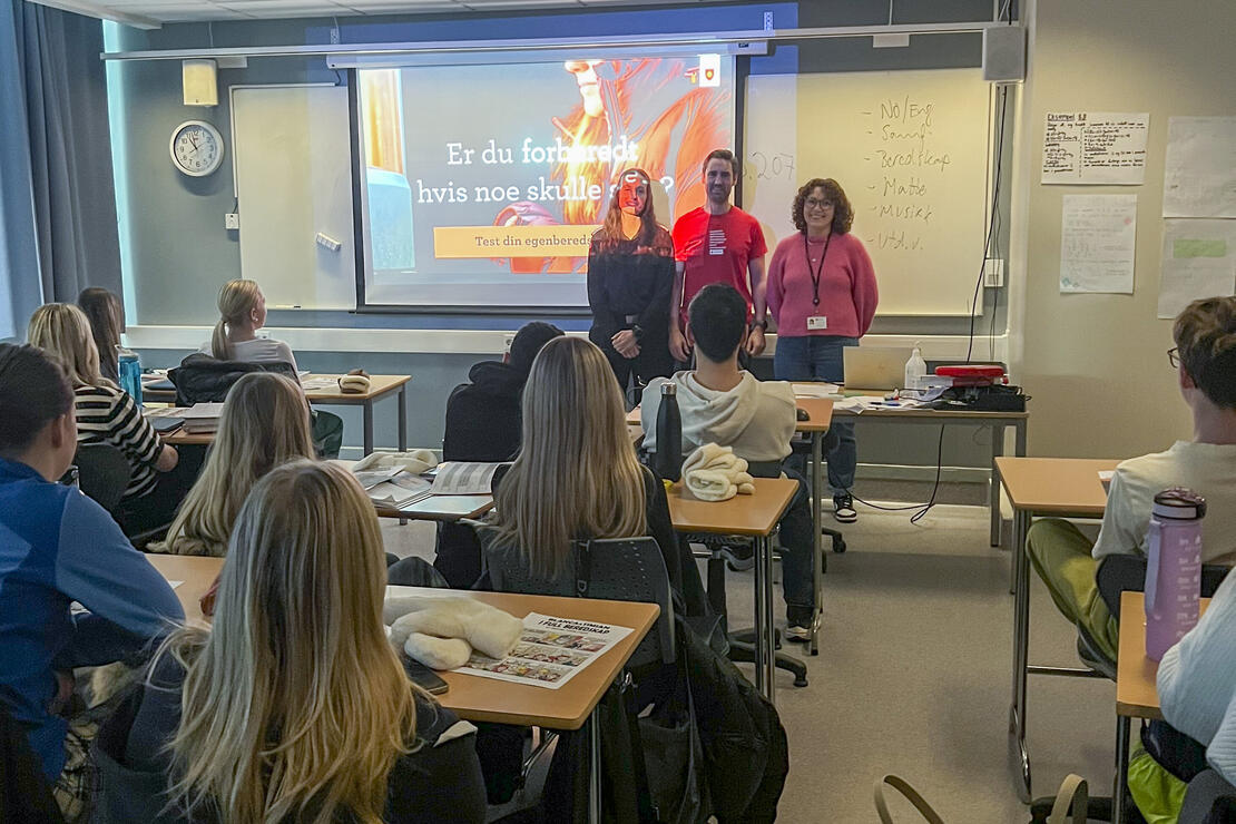 Bildet viser tre personer som holder foredrag foran elever i et klasserom. Lysbilde med innhold fra en av kampanjene under Egenberedskapsuka 2023. 