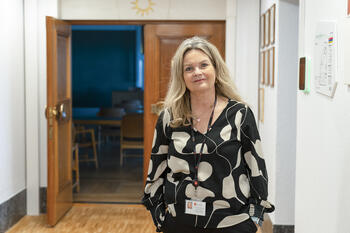 Bildet viser Elisabeth Ellingsen som står inne i gangen foran inngangen til bystyresalen på rådhuset i Bodø. 